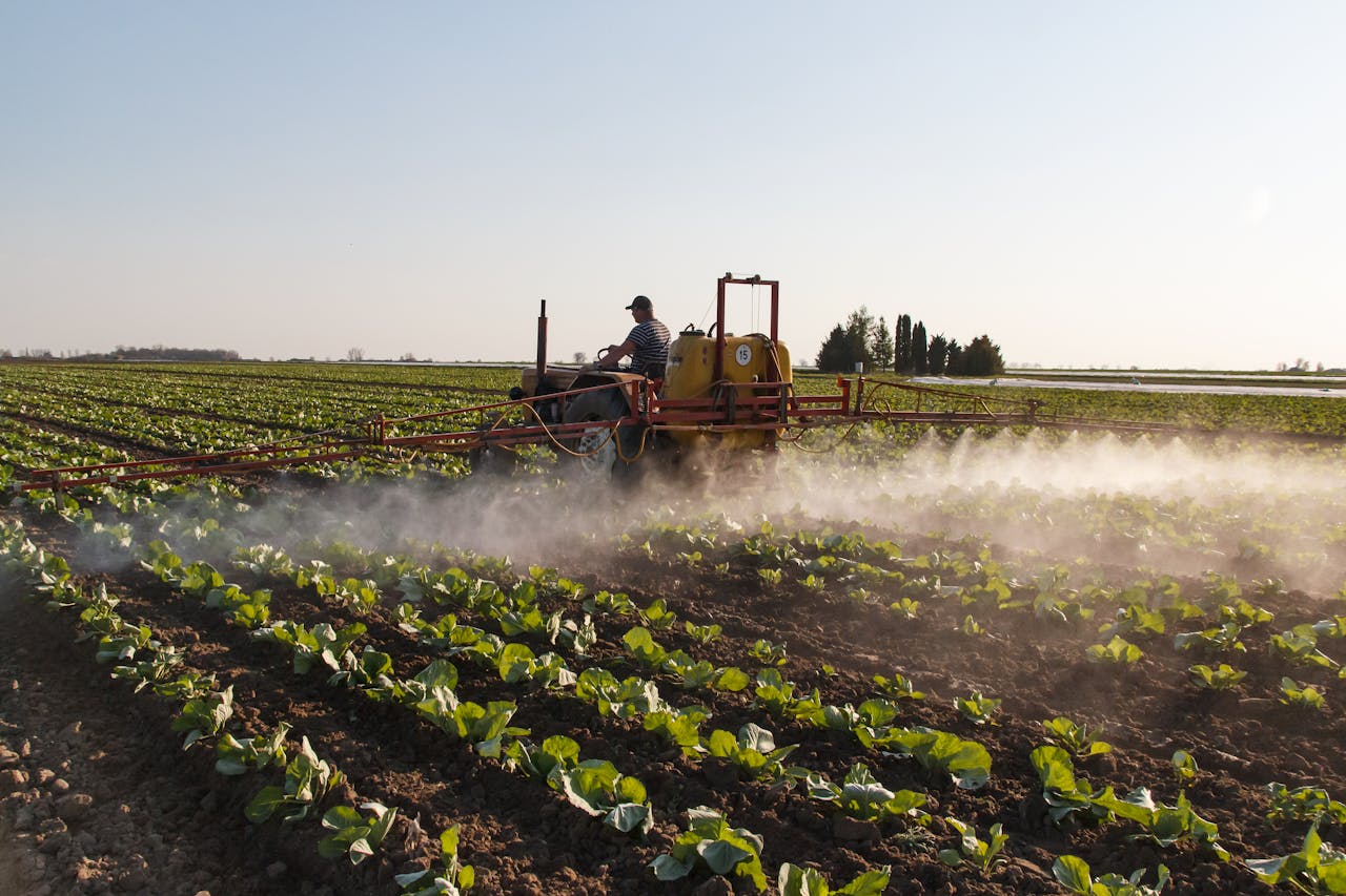 Why This New AI App Could Replace Your Personal Assistant Tractor spraying crops in a vast farmland at sunrise, promoting growth and efficiency.