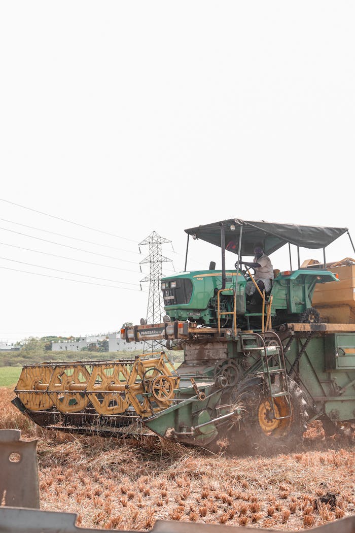 Green combine harvester working in a field during harvest season.